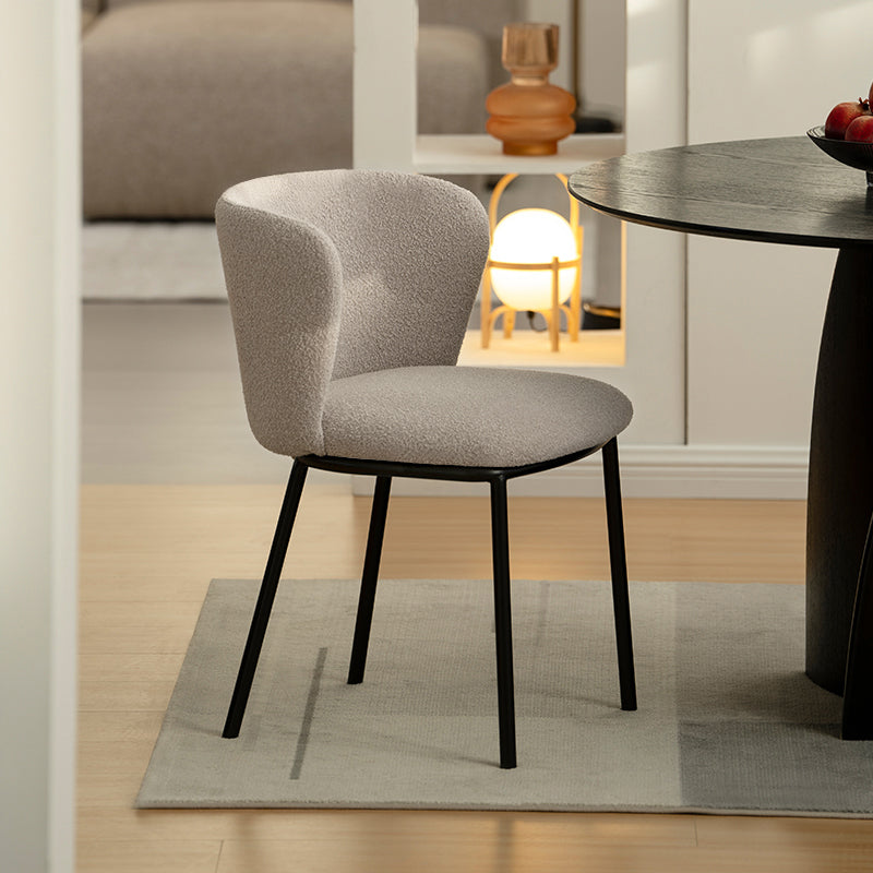 Chaise design Karin en tissu bouclé beige, avec dossier large et pieds en métal noir. Parfaite pour salle à manger, cuisine ou bureau. Collection OFCASA.