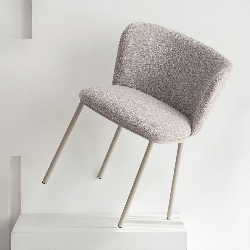 Chaise design Karin en tissu bouclé beige, avec dossier large et pieds en métal noir. Parfaite pour salle à manger, cuisine ou bureau. Collection OFCASA.