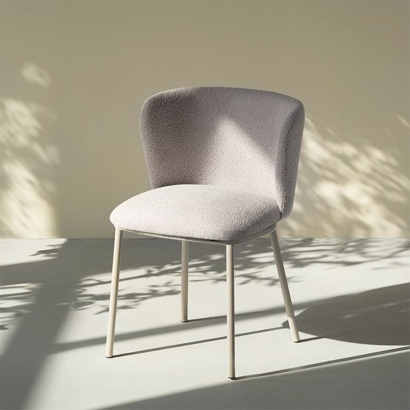 Chaise design Karin en tissu bouclé beige, avec dossier large et pieds en métal noir. Parfaite pour salle à manger, cuisine ou bureau. Collection OFCASA.