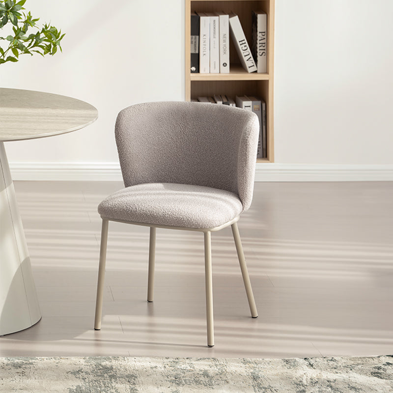 Chaise design Karin en tissu bouclé beige, avec dossier large et pieds en métal noir. Parfaite pour salle à manger, cuisine ou bureau. Collection OFCASA.