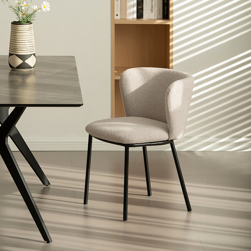 Chaise design Karin en tissu bouclé beige, avec dossier large et pieds en métal noir. Parfaite pour salle à manger, cuisine ou bureau. Collection OFCASA.