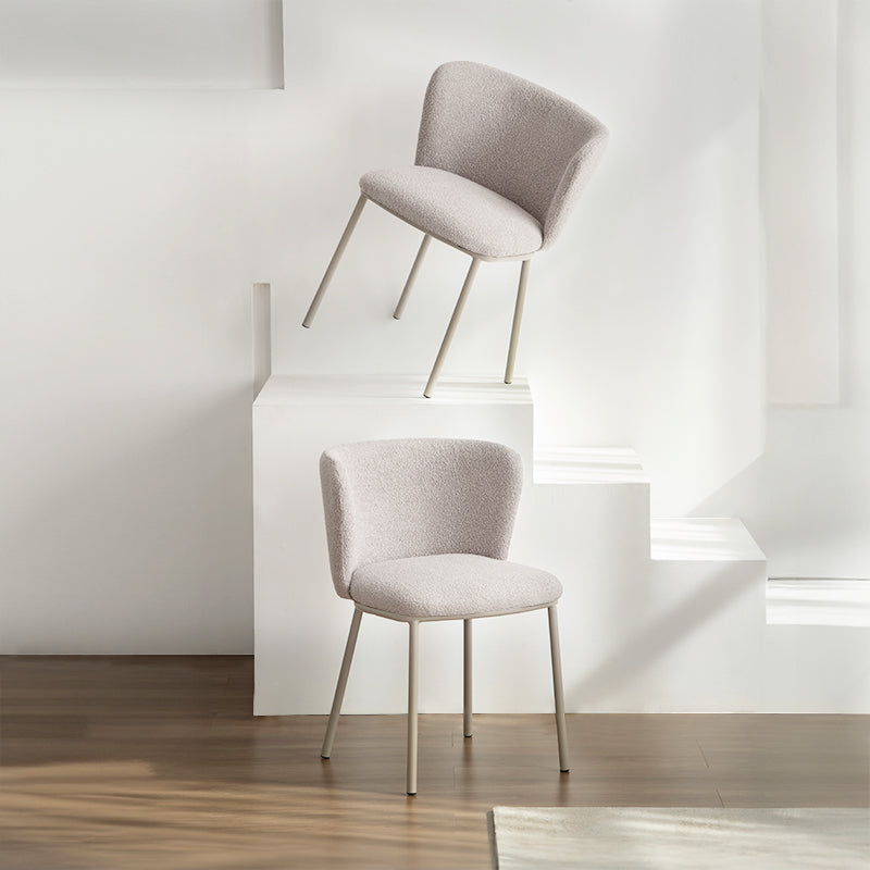 Chaise design Karin en tissu bouclé beige, avec dossier large et pieds en métal noir. Parfaite pour salle à manger, cuisine ou bureau. Collection OFCASA.