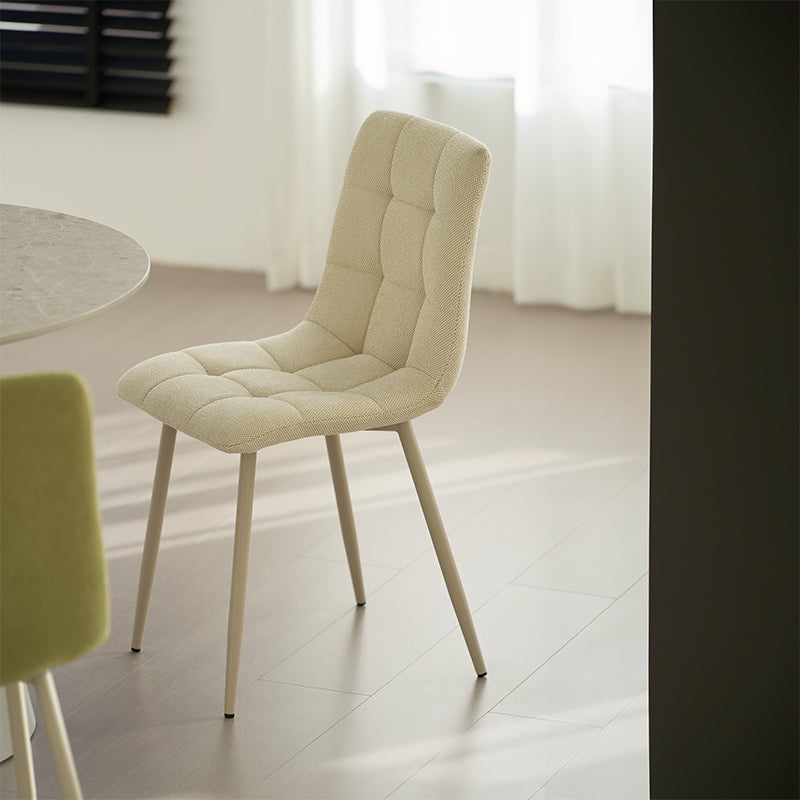 Alliez confort et style avec la chaise Aoife : revêtement en lin mélangé, surpiqûres en losange et pieds métalliques fins pour une élégance moderne.
