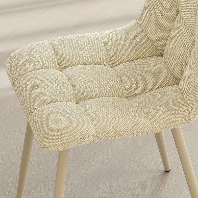 Alliez confort et style avec la chaise Aoife : revêtement en lin mélangé, surpiqûres en losange et pieds métalliques fins pour une élégance moderne.
