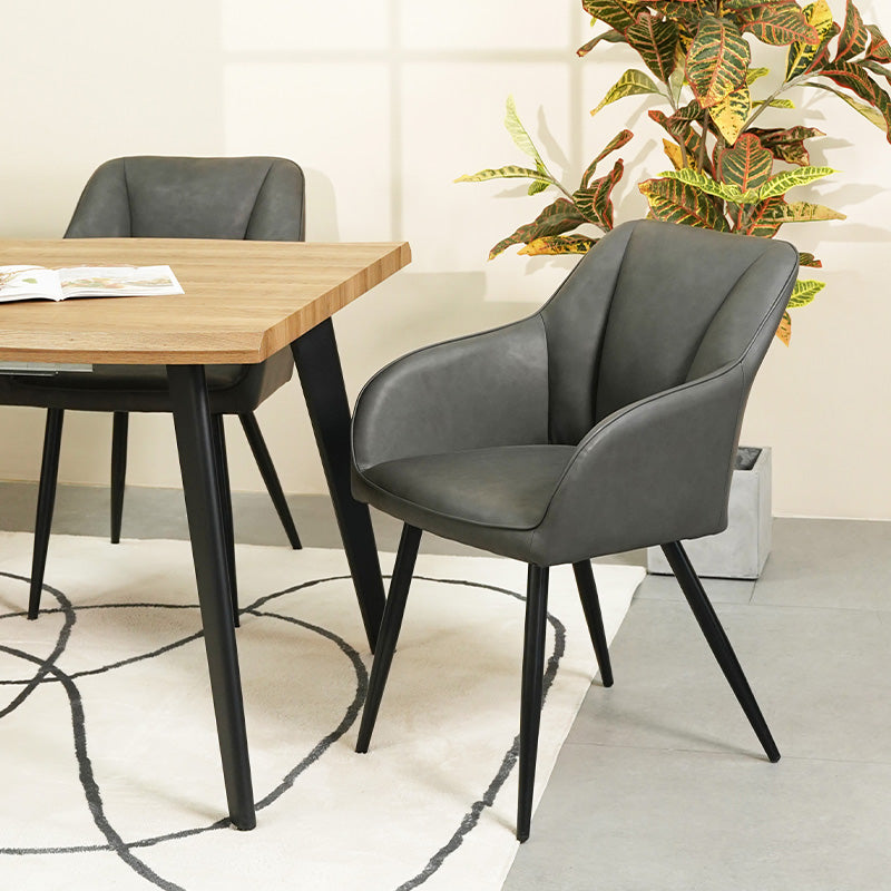 Lot de 4 chaises design Sienna d'OFCASA avec assise rembourrée grise et pieds métal noir, autour d'une table en bois，Chaise de salle à manger Sienna en contexte réel, montrant son dossier ergonomique et son style contemporain